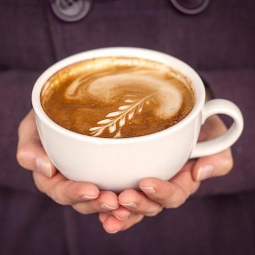 关闭-up of hands holding a latte with latte art
